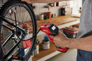 Photo of Craftsman handheld inflator CMCE521B inflating a bicycle tire in a garage workspace.