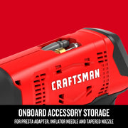 Close-up of CRAFTSMAN CMCE521B inflator with onboard accessory storage for adapters and nozzles, red and black housing.