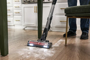 Craftsman CMCVS501M1 cordless stick vacuum cleaning flour on wood floor in kitchen, side angle.