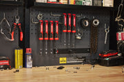A workshop scene showing a pegboard with various tools including a set of CRAFTSMAN nut drivers with red handles, pliers