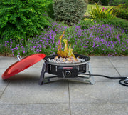 CRAFTSMAN CMXBHBB17003 outdoor gas fire pit with red lid on patio, flame burning, garden in background.