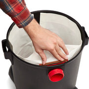 Photo of a hand installing a dust bag inside a black Craftsman wet/dry vacuum, SKU CMXZVBE38768, top view.